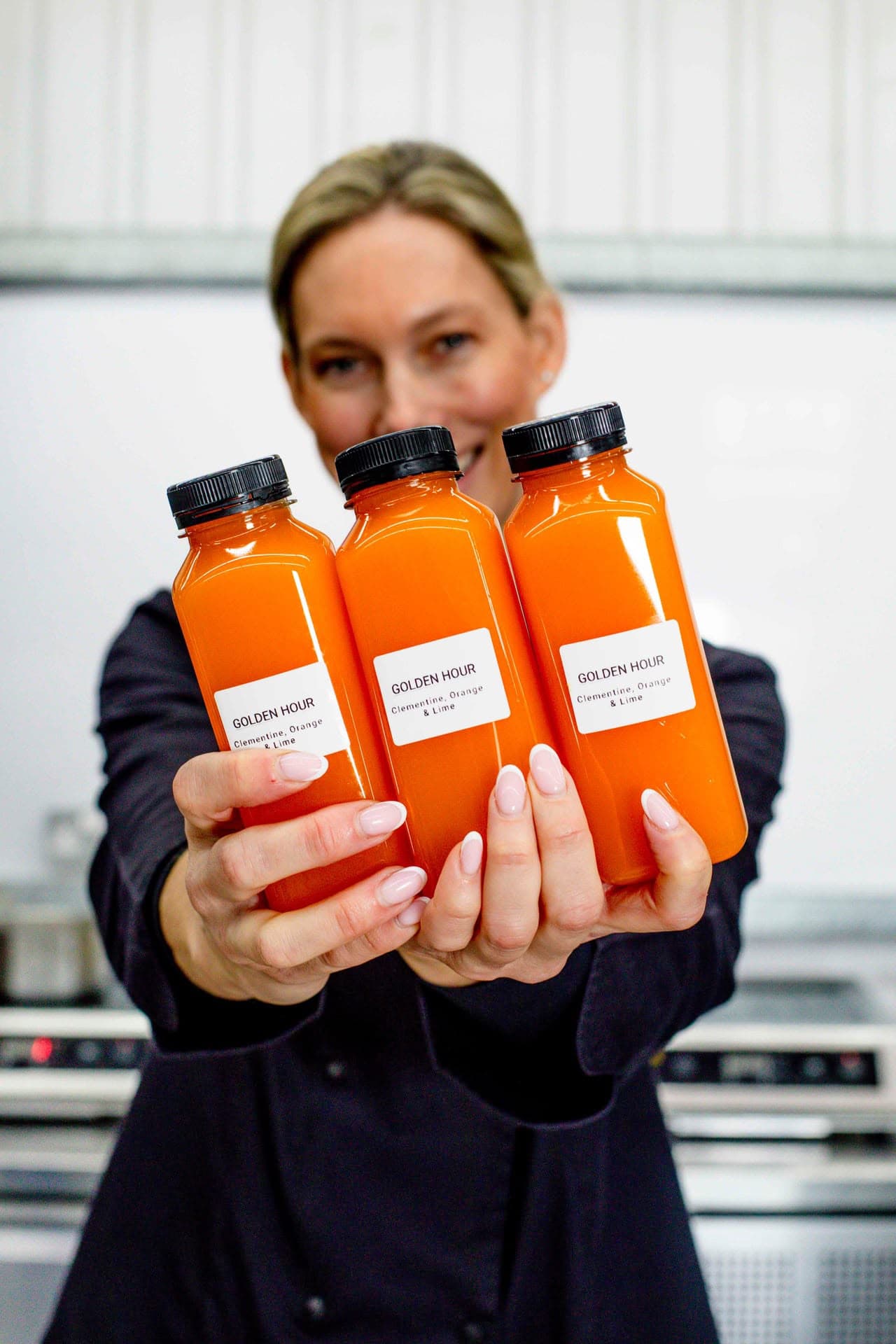 Tamaryn holding a tray of Golden Hour juices