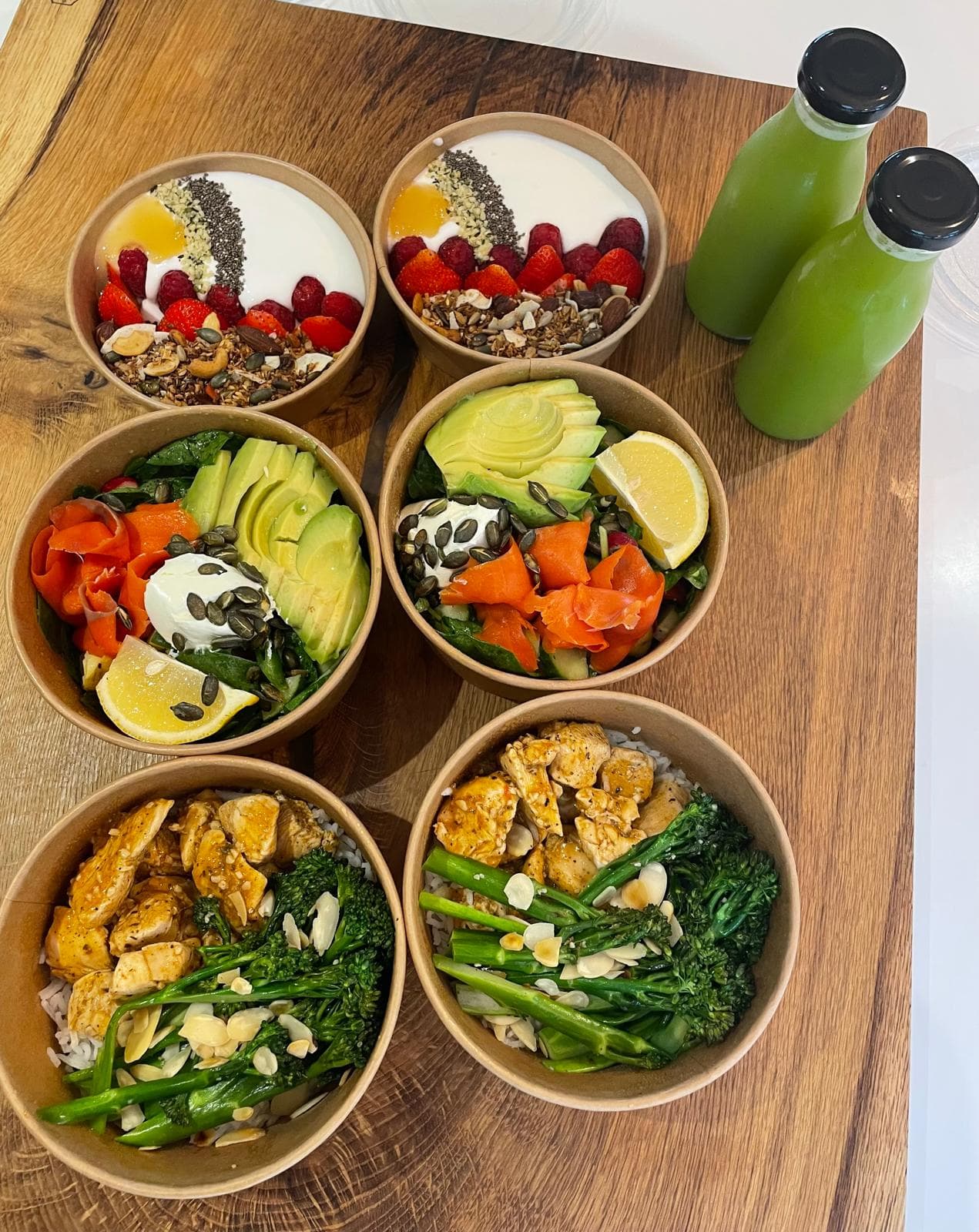 Meal prep bowls with yoghurt granola, salmon and chicken, plus green juices