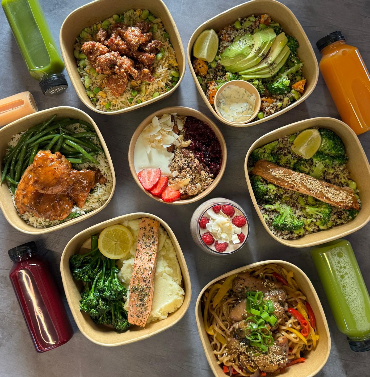 An overhead spread of Tame & True meal boxes, salads and juices